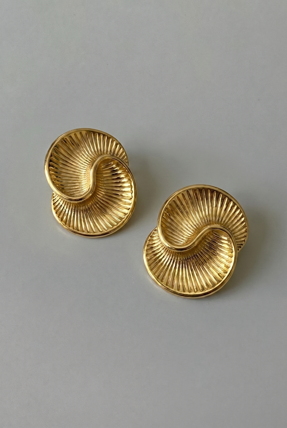 Pair of gold earrings on a gray background