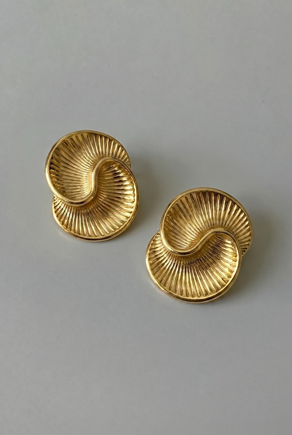Pair of gold earrings on a gray background
