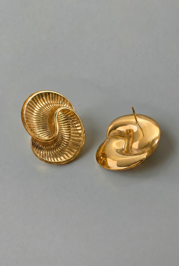 Pair of gold spiral earrings on a gray background
