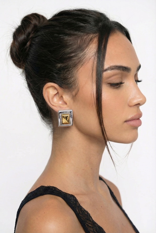 Woman wearing a gold earring with a white background