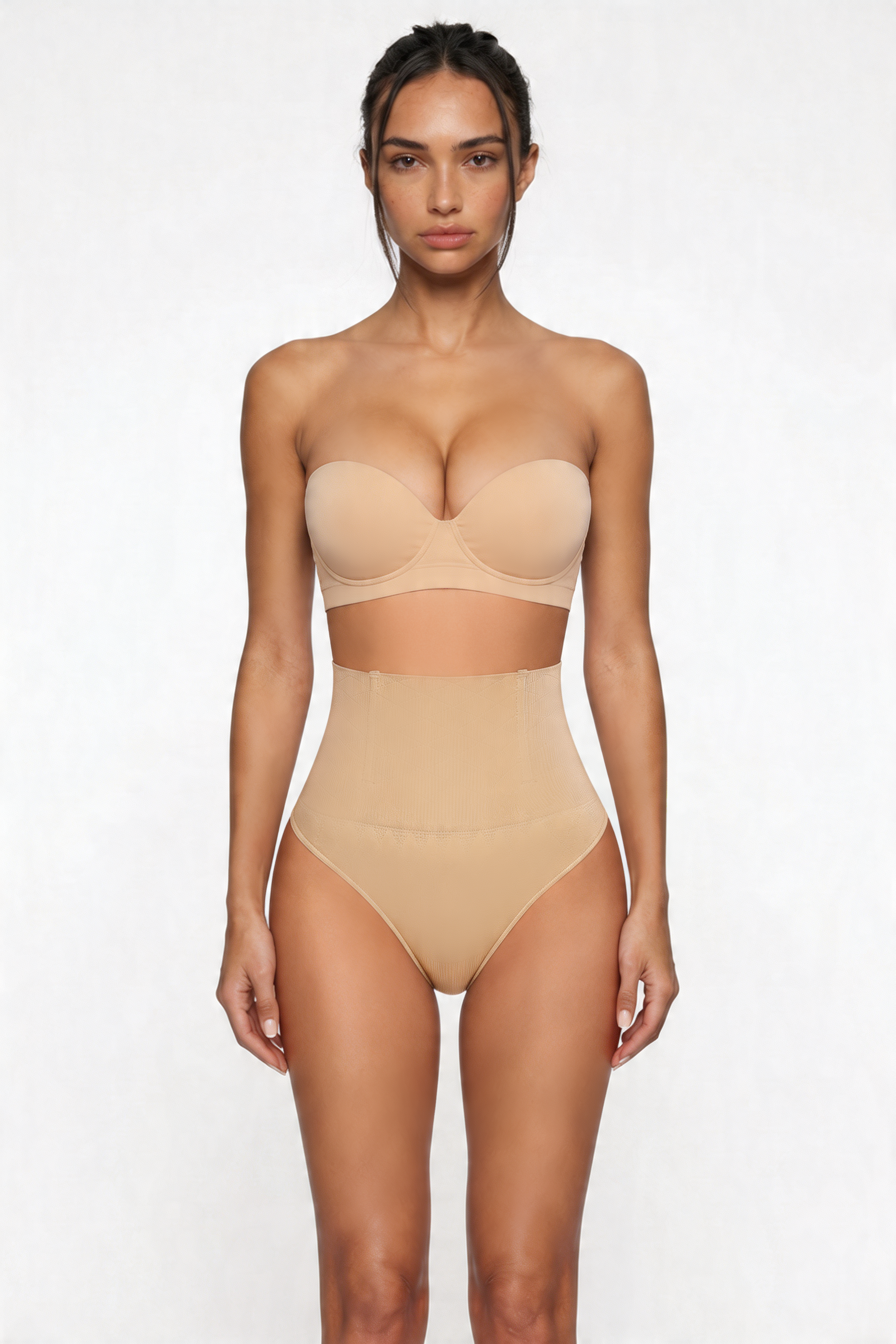 Woman wearing a beige strapless top and high-waisted shapewear bottom on a white background