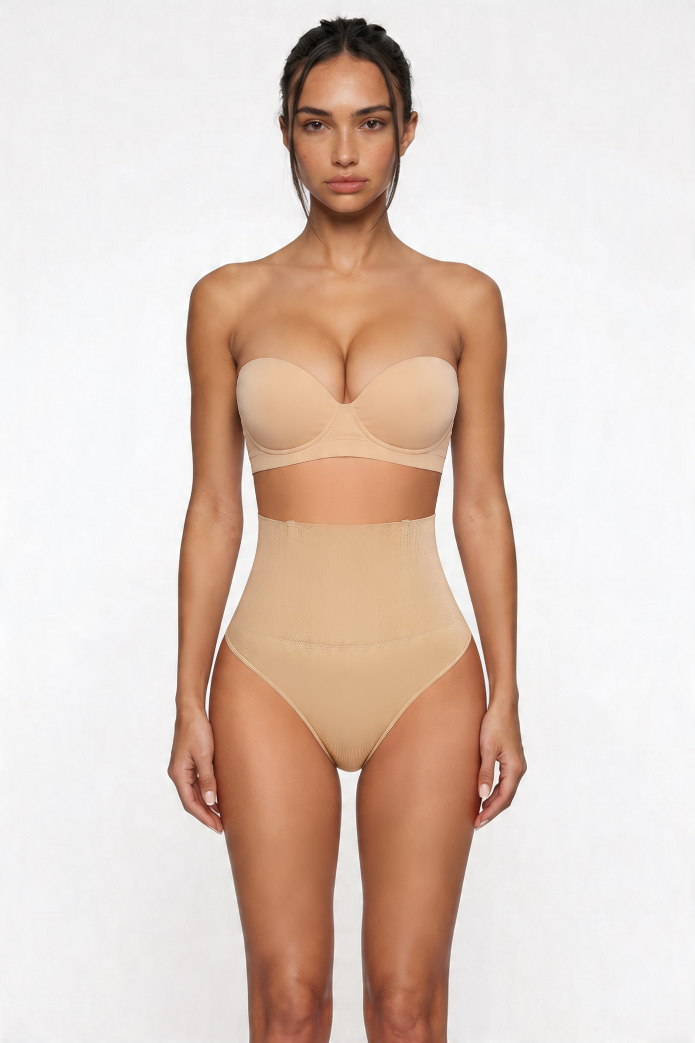Woman wearing a beige strapless top and high-waisted shapewear bottom on a white background