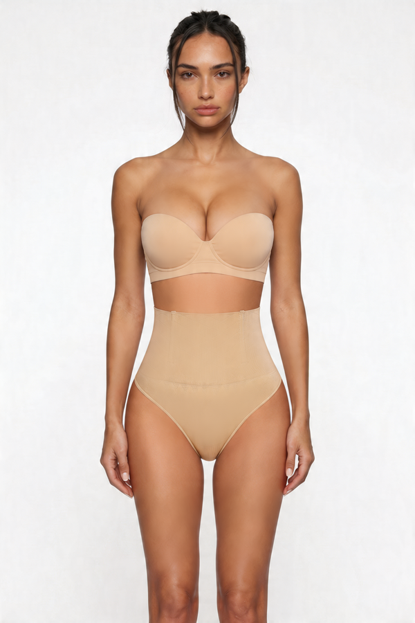 Woman wearing a beige strapless top and high-waisted shapewear bottom on a white background