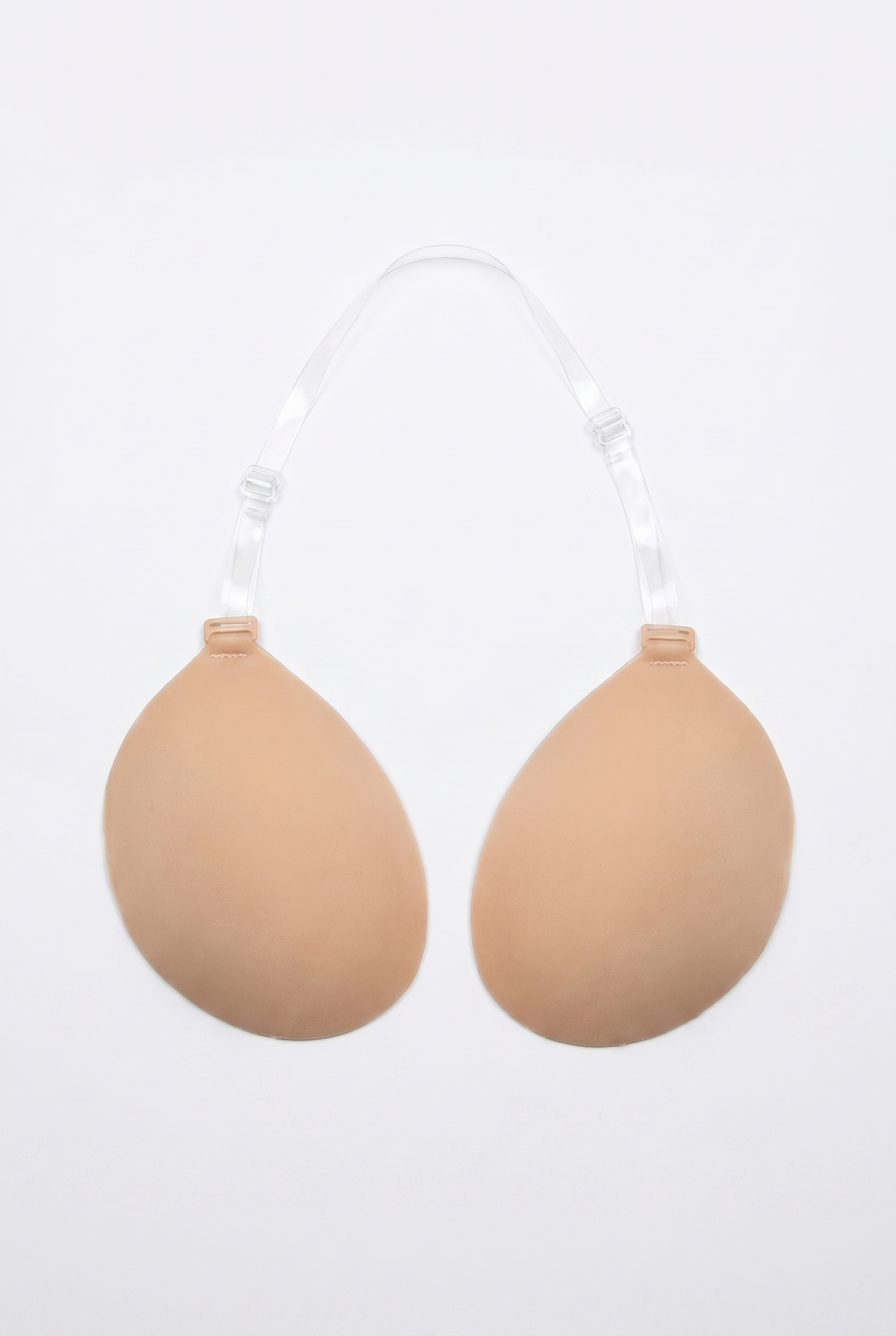 Beige breast enhancement inserts on a white background