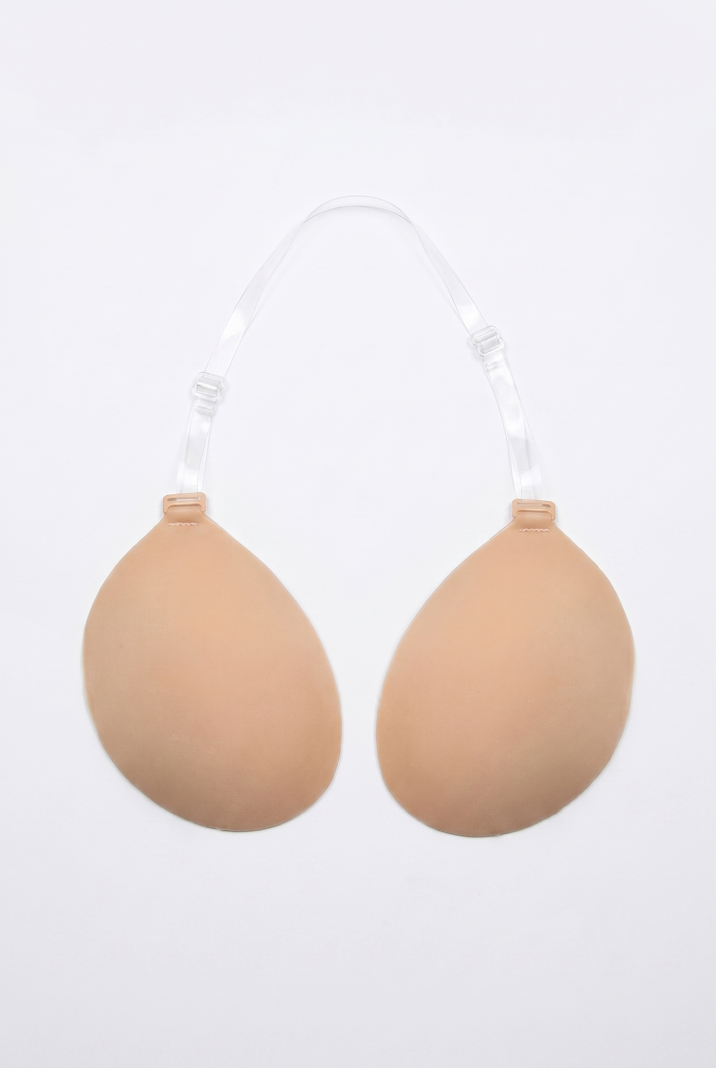 Beige breast enhancement inserts on a white background