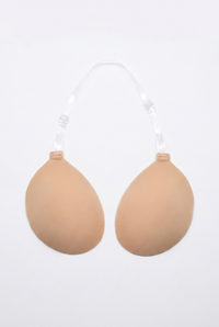 Beige breast enhancement inserts on a white background