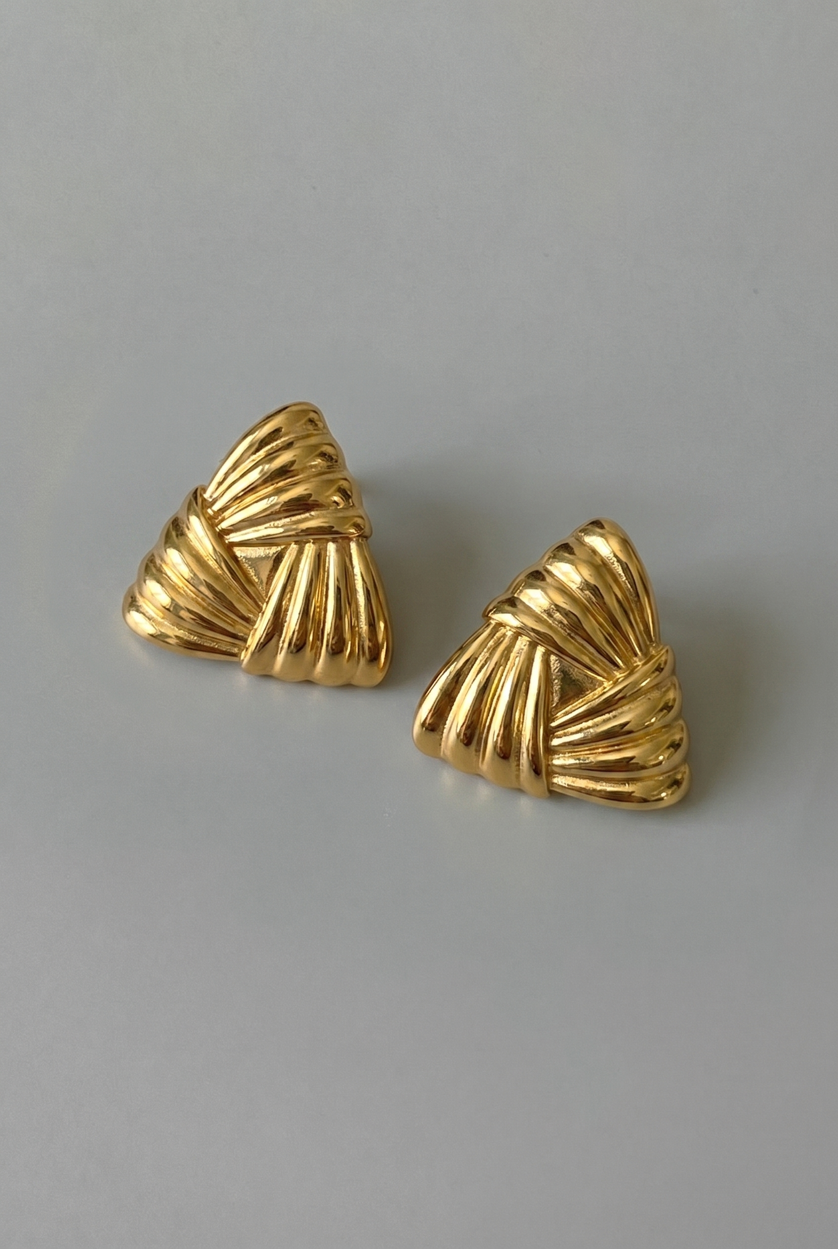 Pair of gold earrings on a gray background