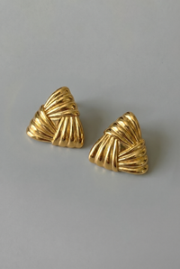 Pair of gold earrings on a gray background