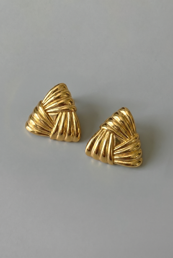 Pair of gold earrings on a gray background
