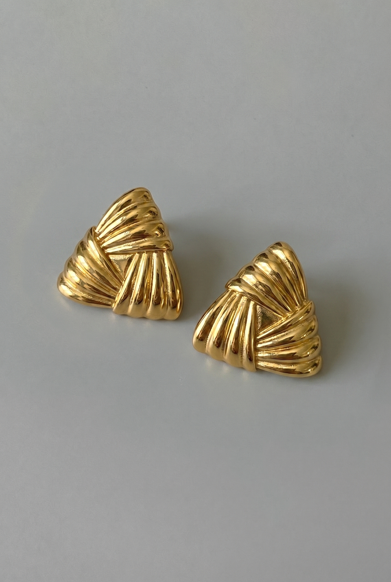 Pair of gold earrings on a gray background