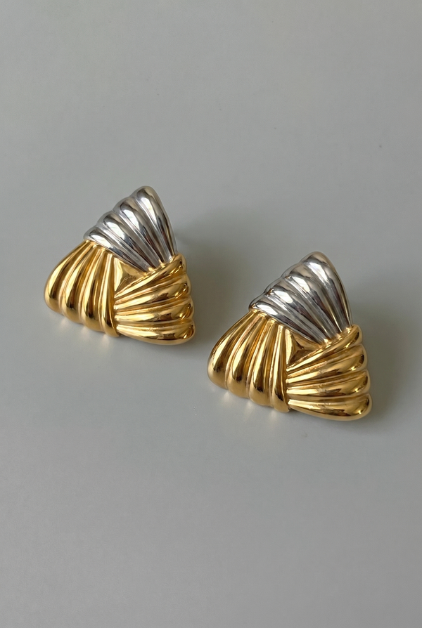 Pair of gold and silver earrings on a gray background