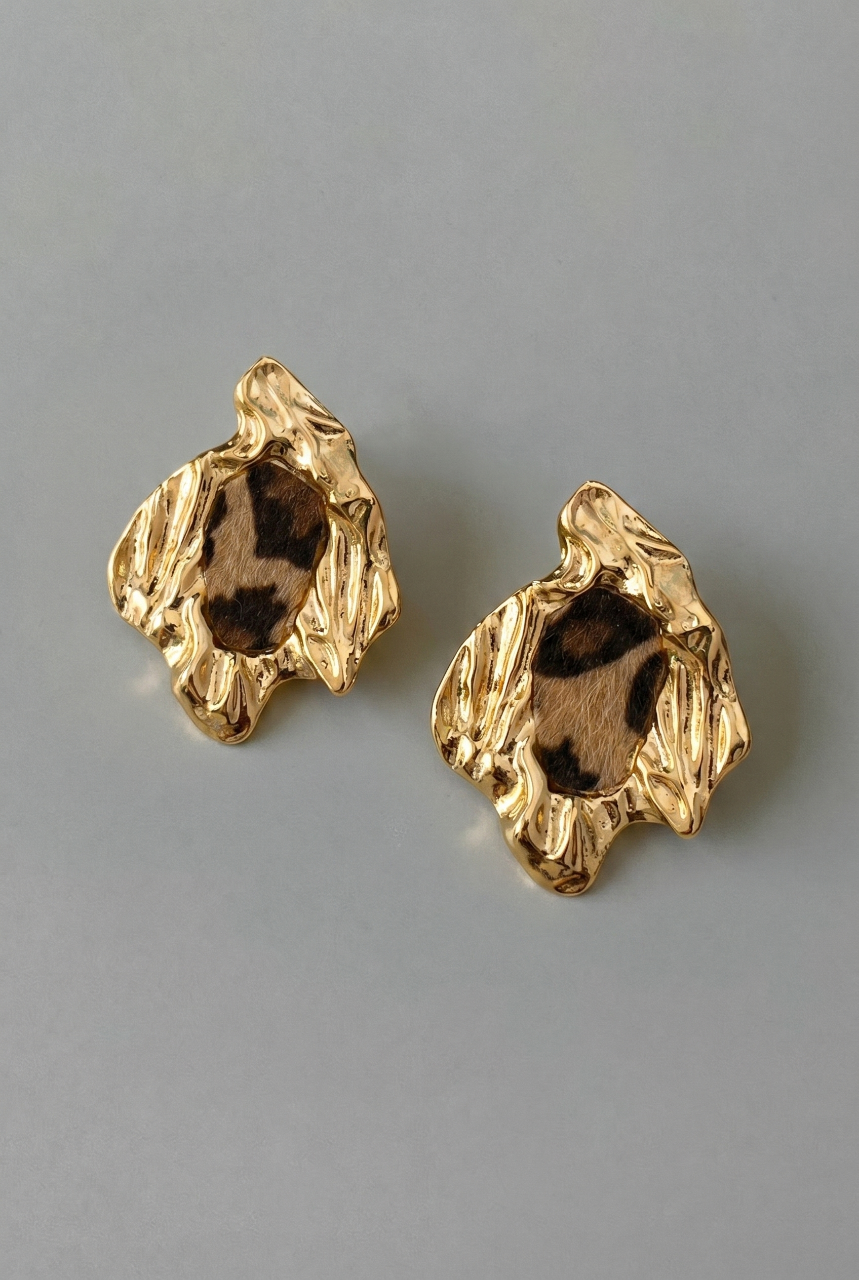 Pair of gold earrings on a gray background