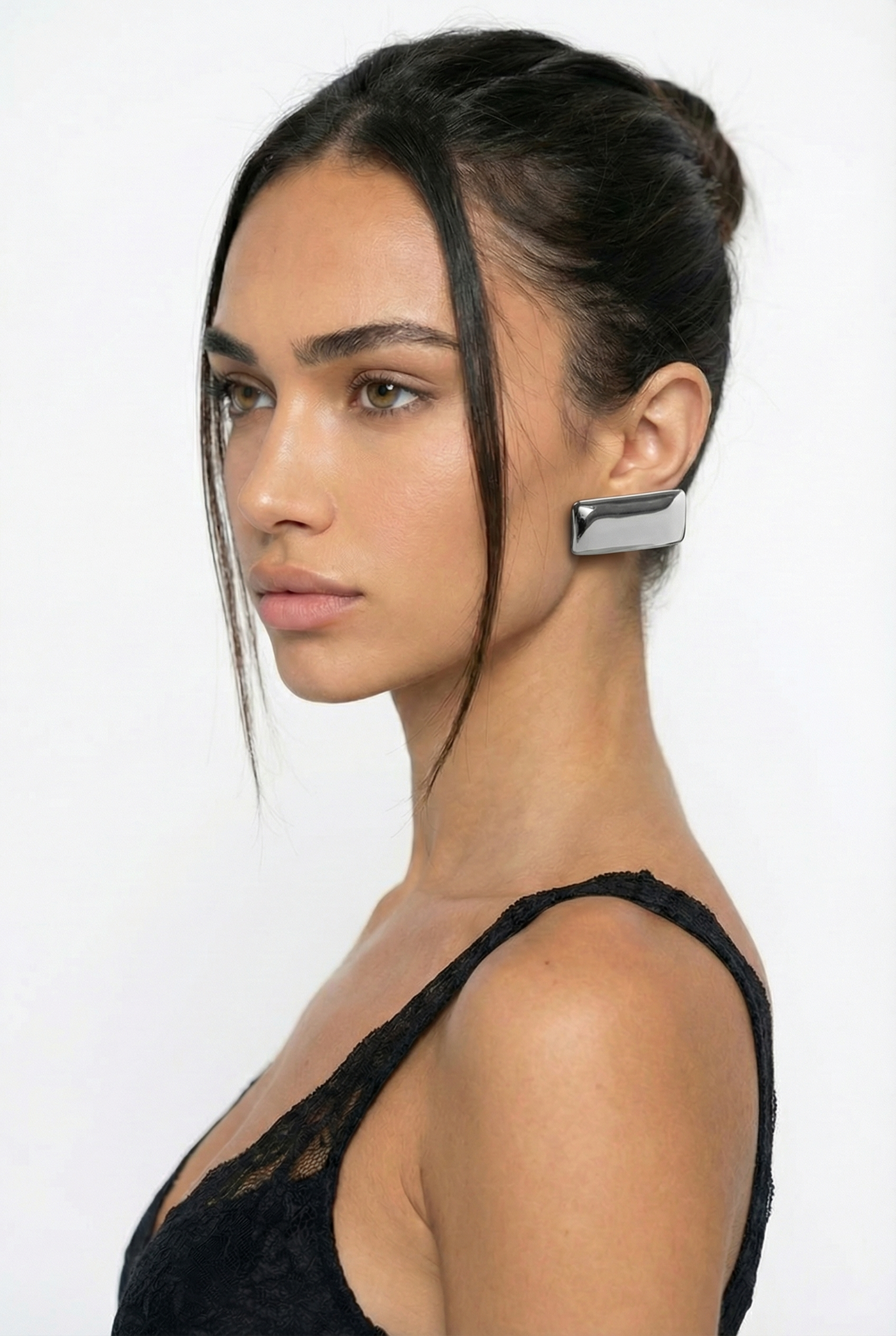 Woman wearing a unique earring on a white background