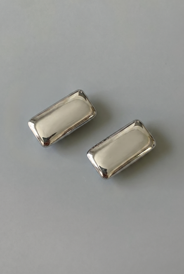 Two silver rectangular objects on a gray background