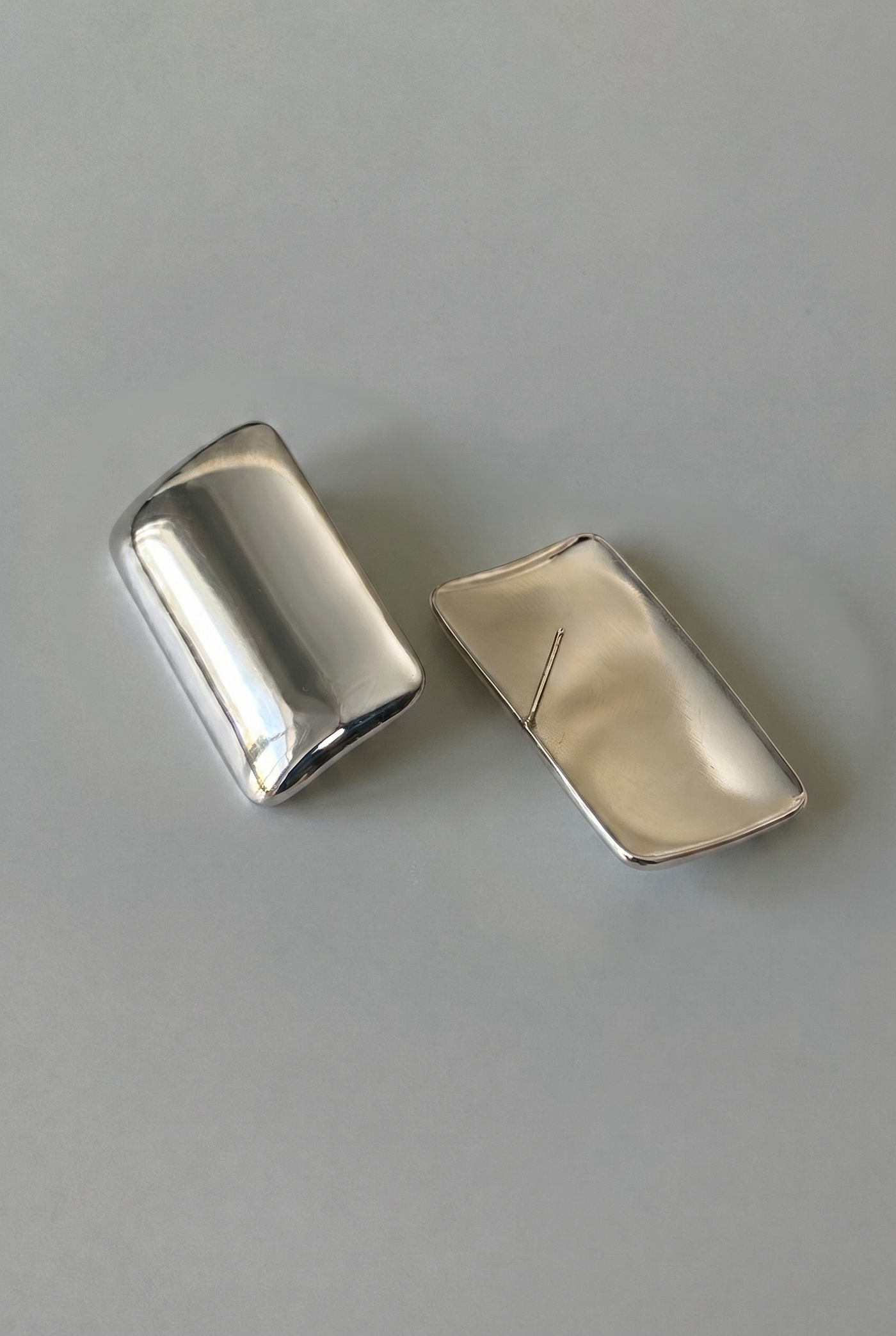 Two silver rectangular objects on a gray background