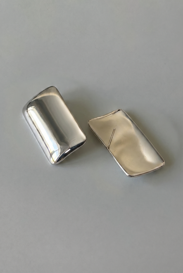 Two silver rectangular objects on a gray background