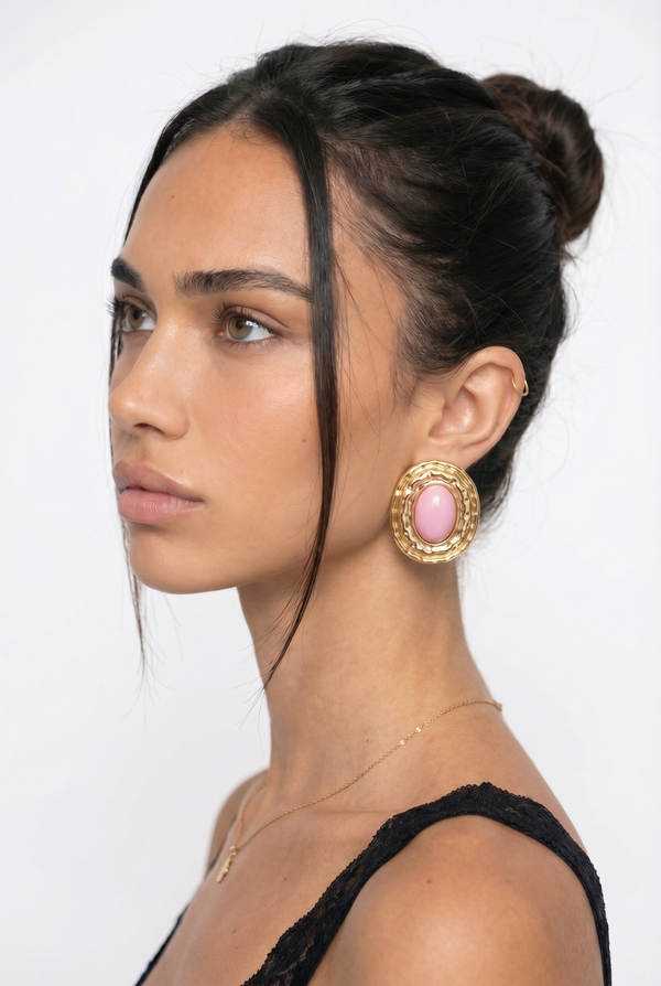 Pair of gold earrings with pink stones on a girl