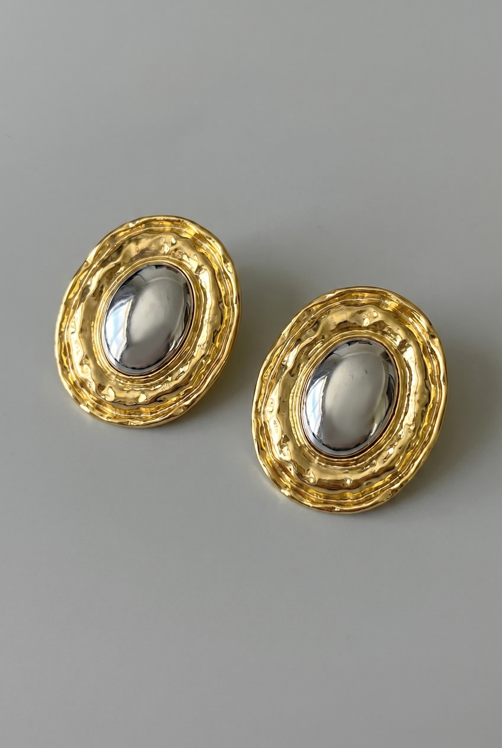 Pair of gold earrings on a gray background