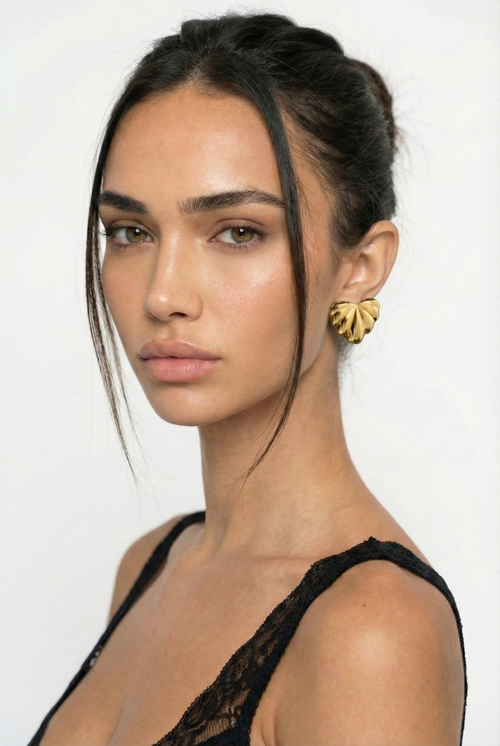 Woman wearing a black lace top with a plain background
