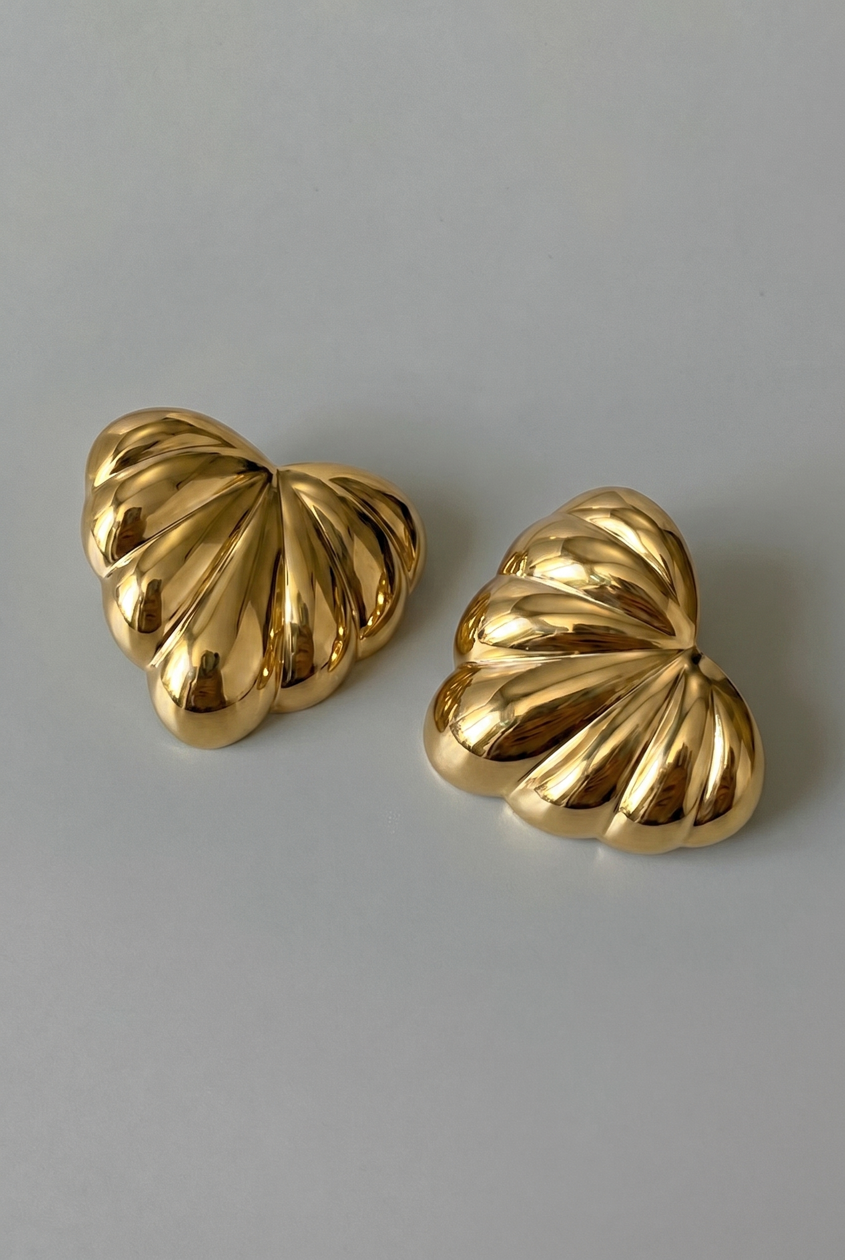 Pair of gold earrings on a gray background