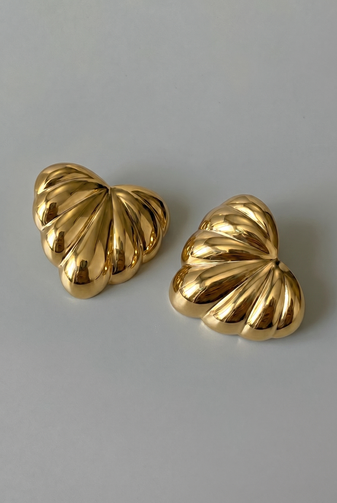 Pair of gold earrings on a gray background