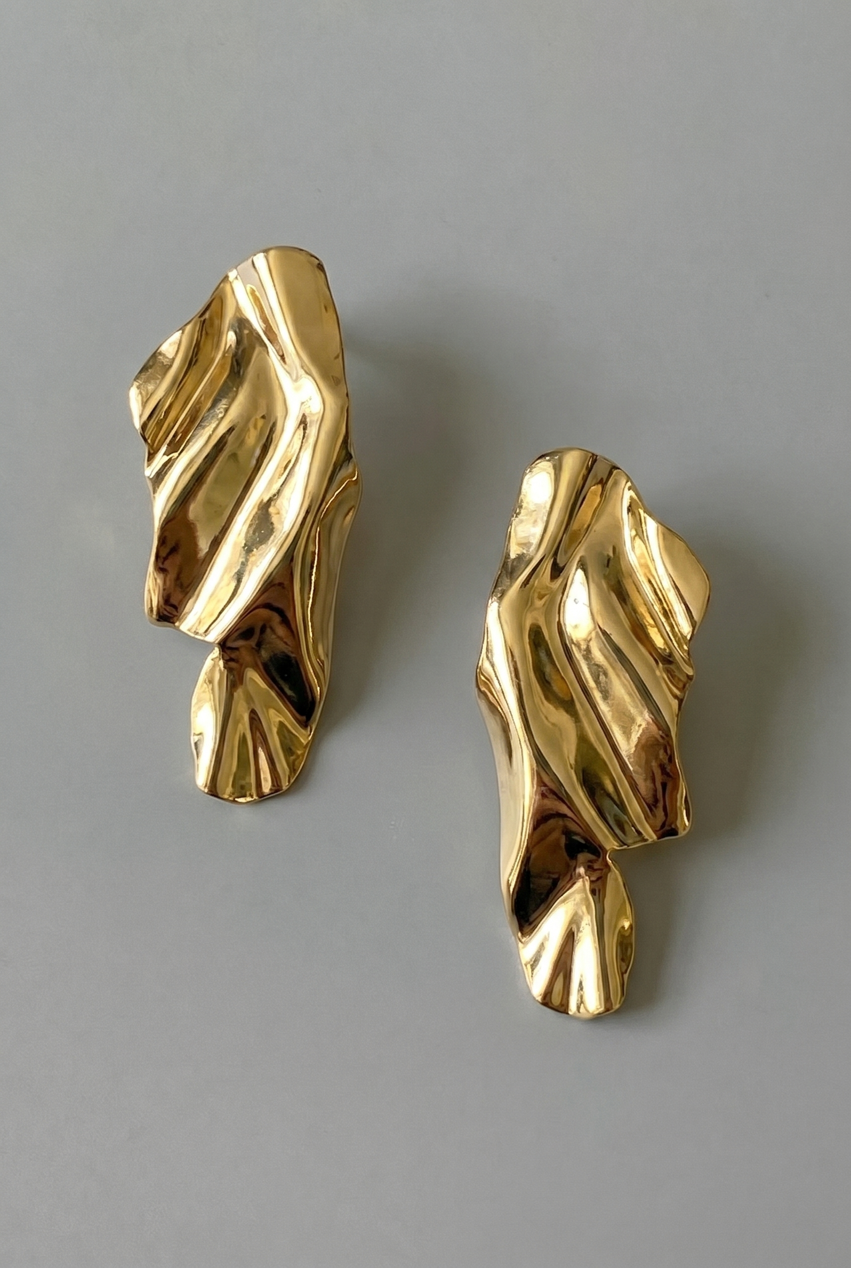 Pair of gold earrings on a gray background