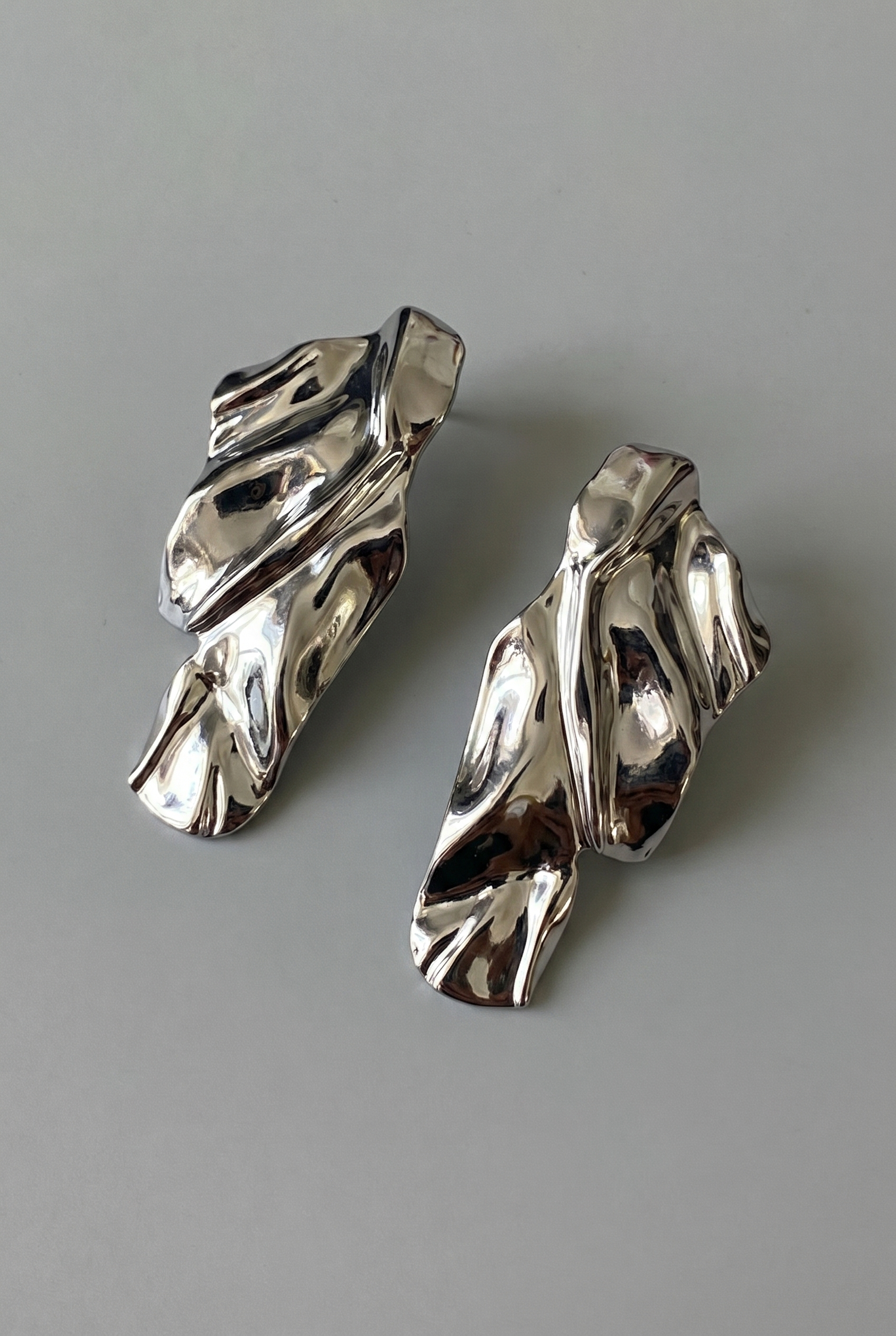 Pair of silver earrings on a gray background
