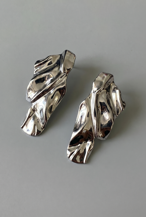 Pair of silver earrings on a gray background