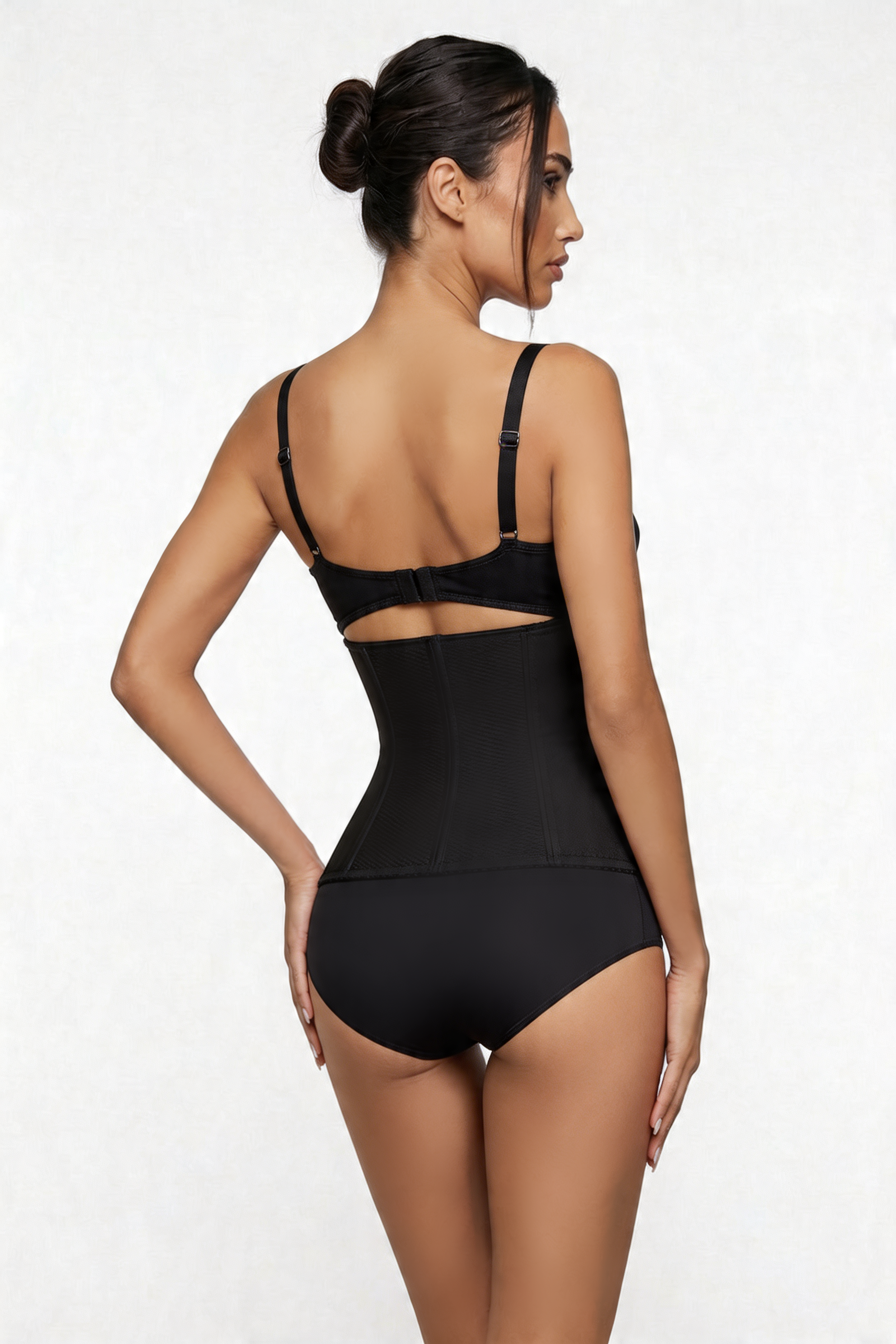 Woman wearing a black shapewear bodysuit on a white background