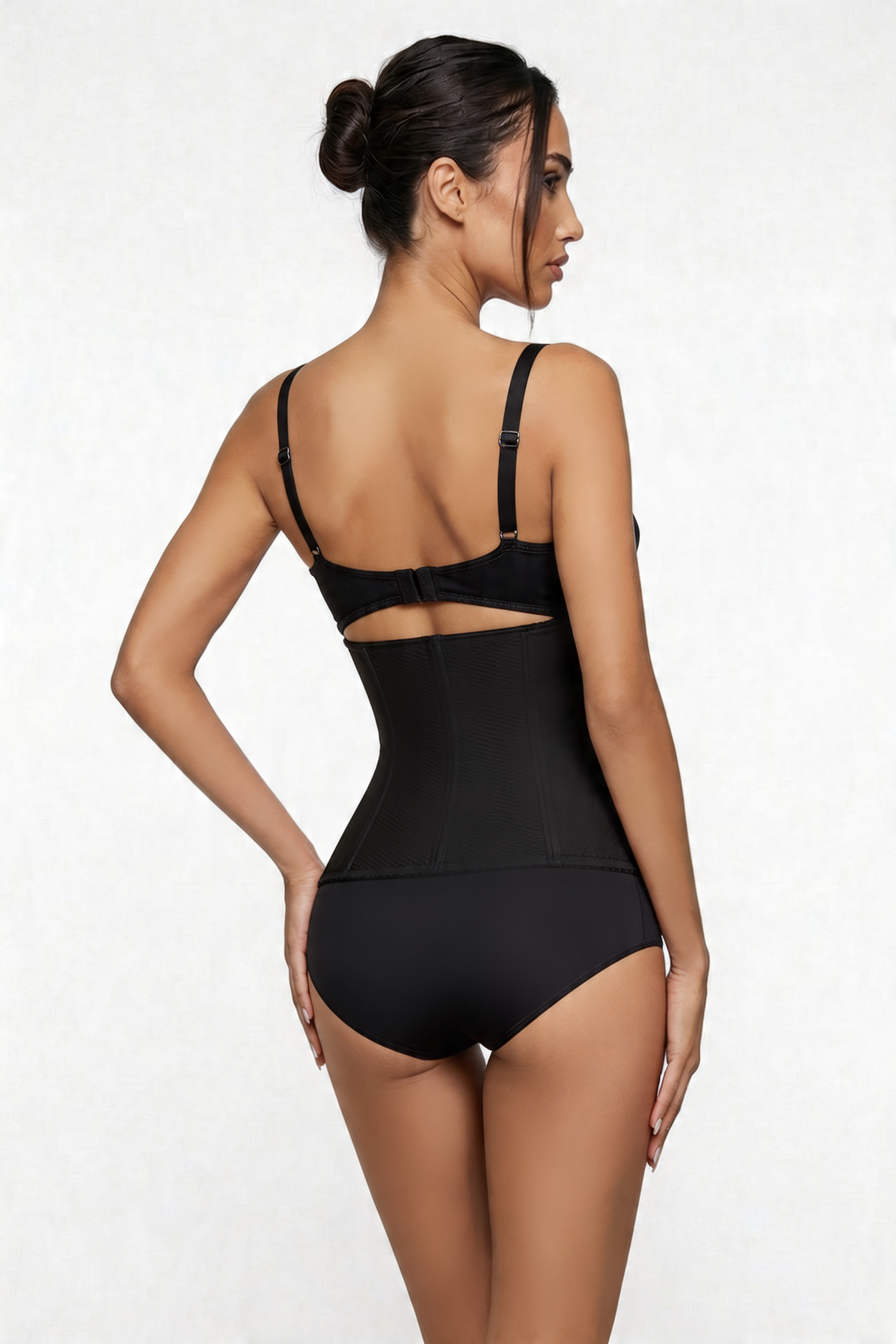Woman wearing a black shapewear bodysuit on a white background