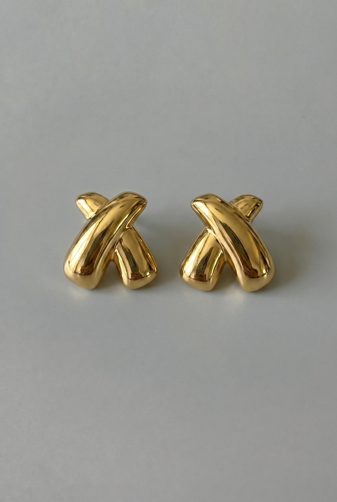 Pair of gold earrings on a gray background