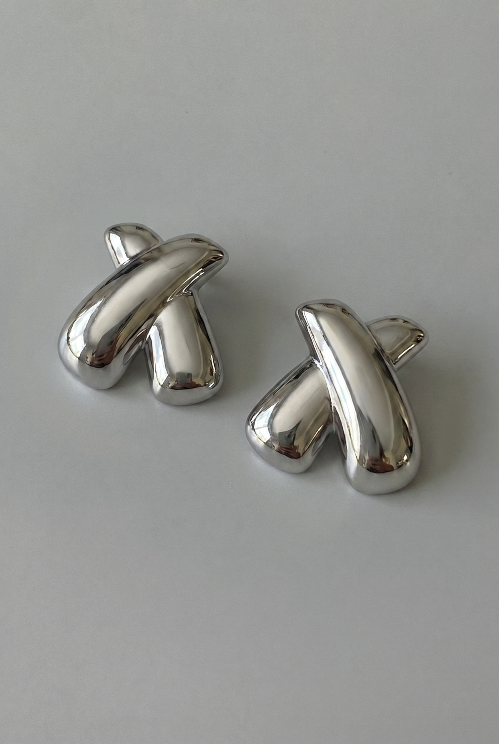 Pair of silver cufflinks on a light gray background