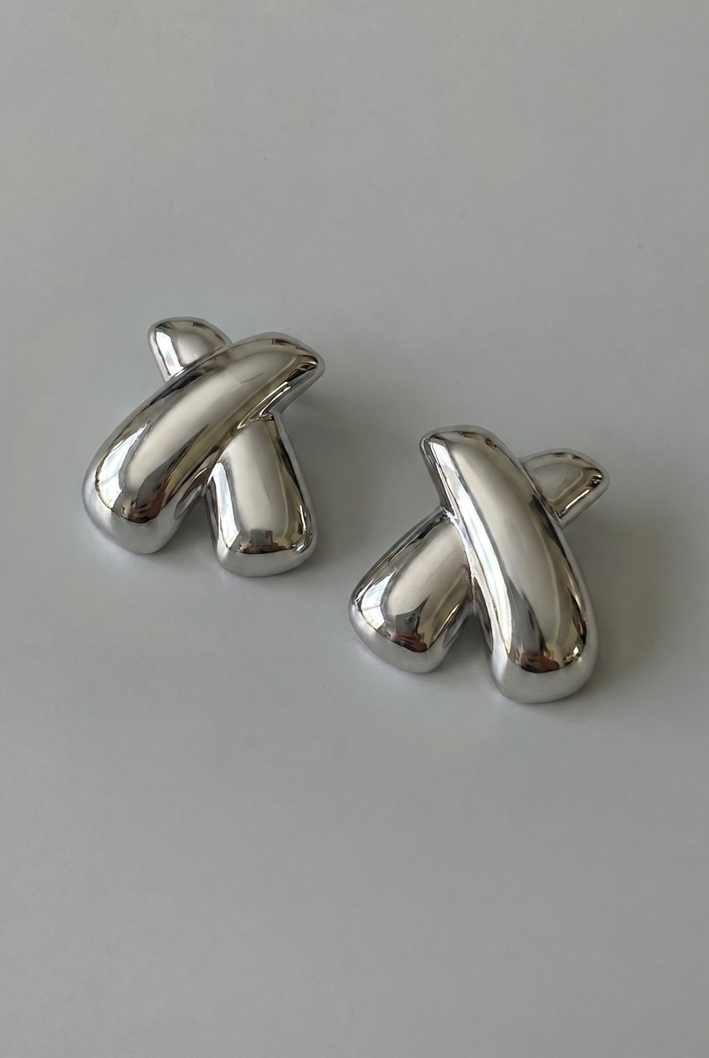 Pair of silver cufflinks on a light gray background