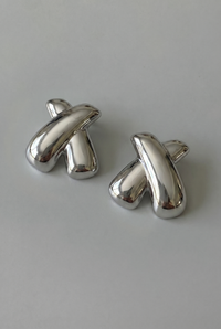 Pair of silver cufflinks on a light gray background