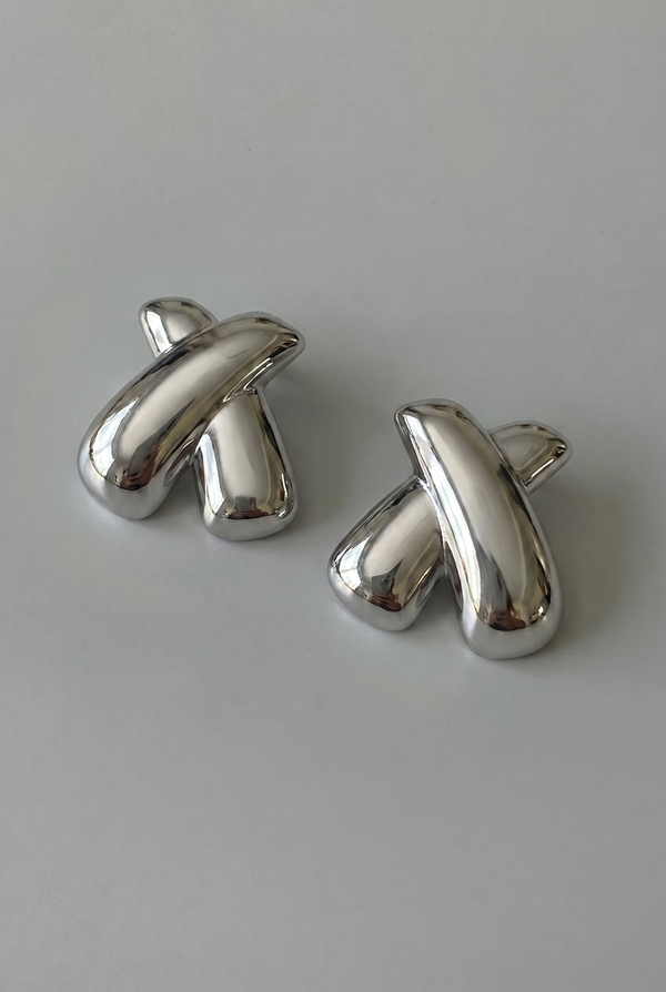 Pair of silver cufflinks on a light gray background