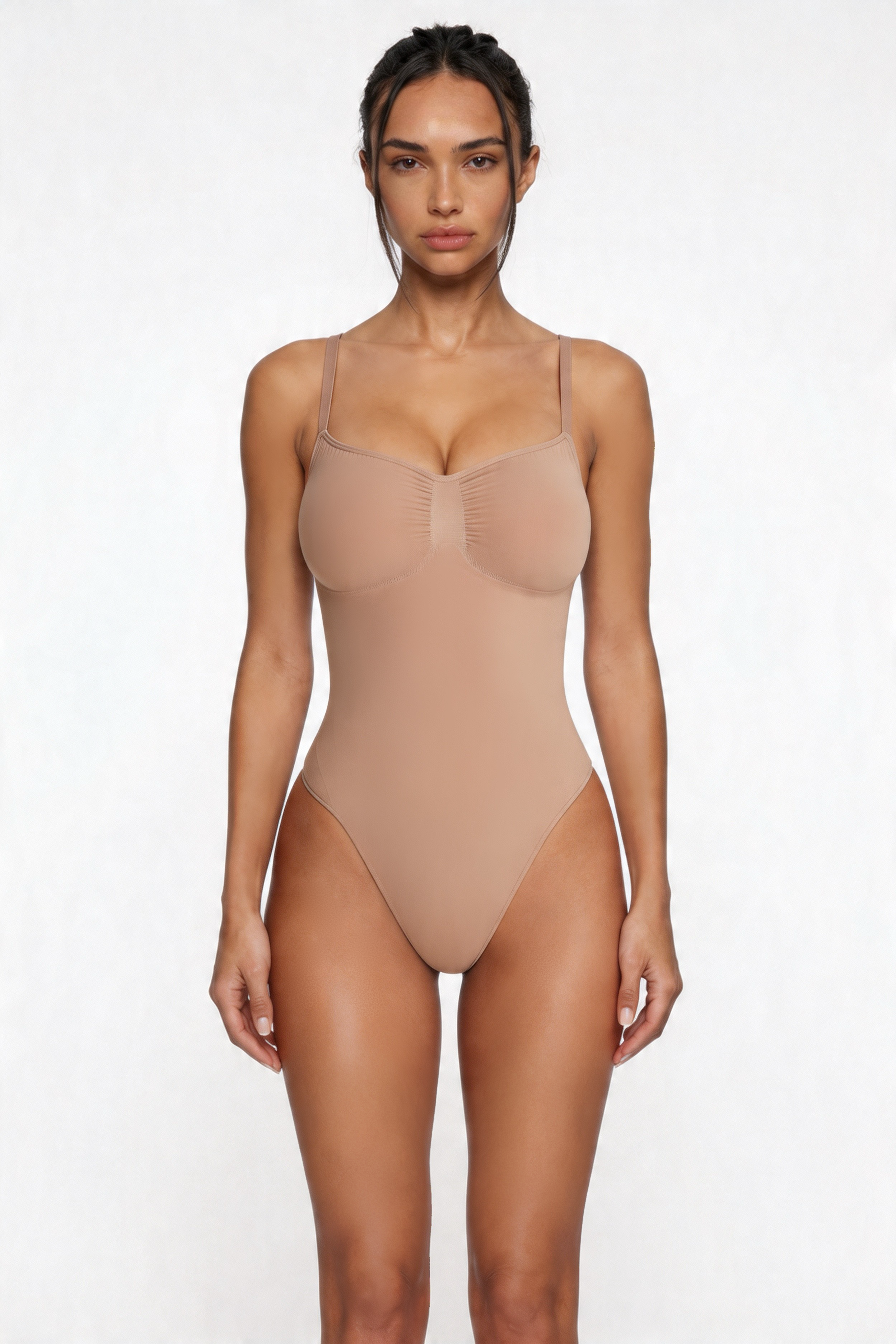 Woman wearing a beige shapewear bodysuit against a white background