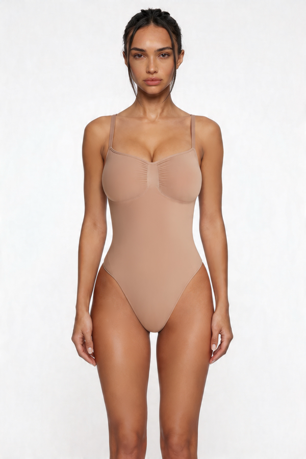 Woman wearing a beige shapewear bodysuit against a white background