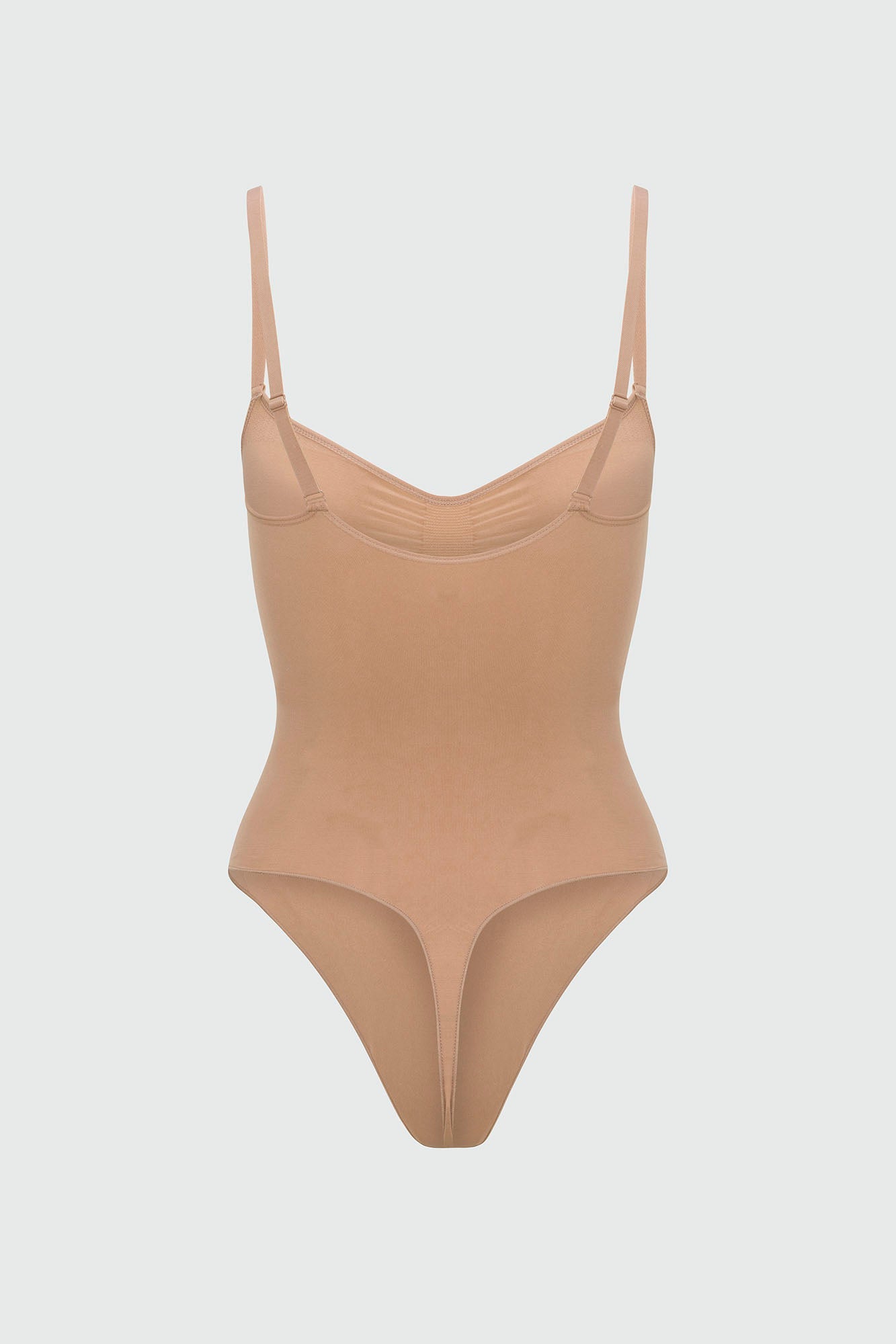 Beige shapewear bodysuit with thin straps on a light gray background