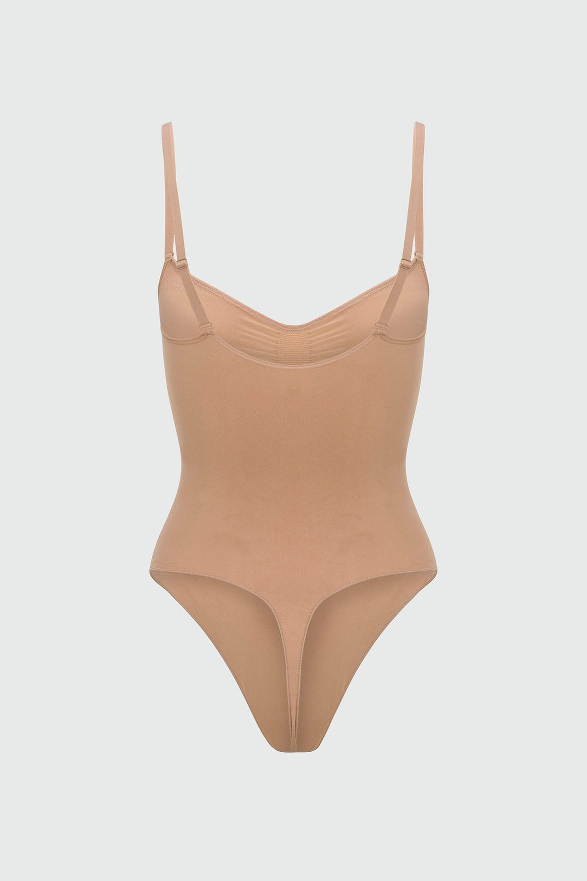 Beige shapewear bodysuit with thin straps on a light gray background
