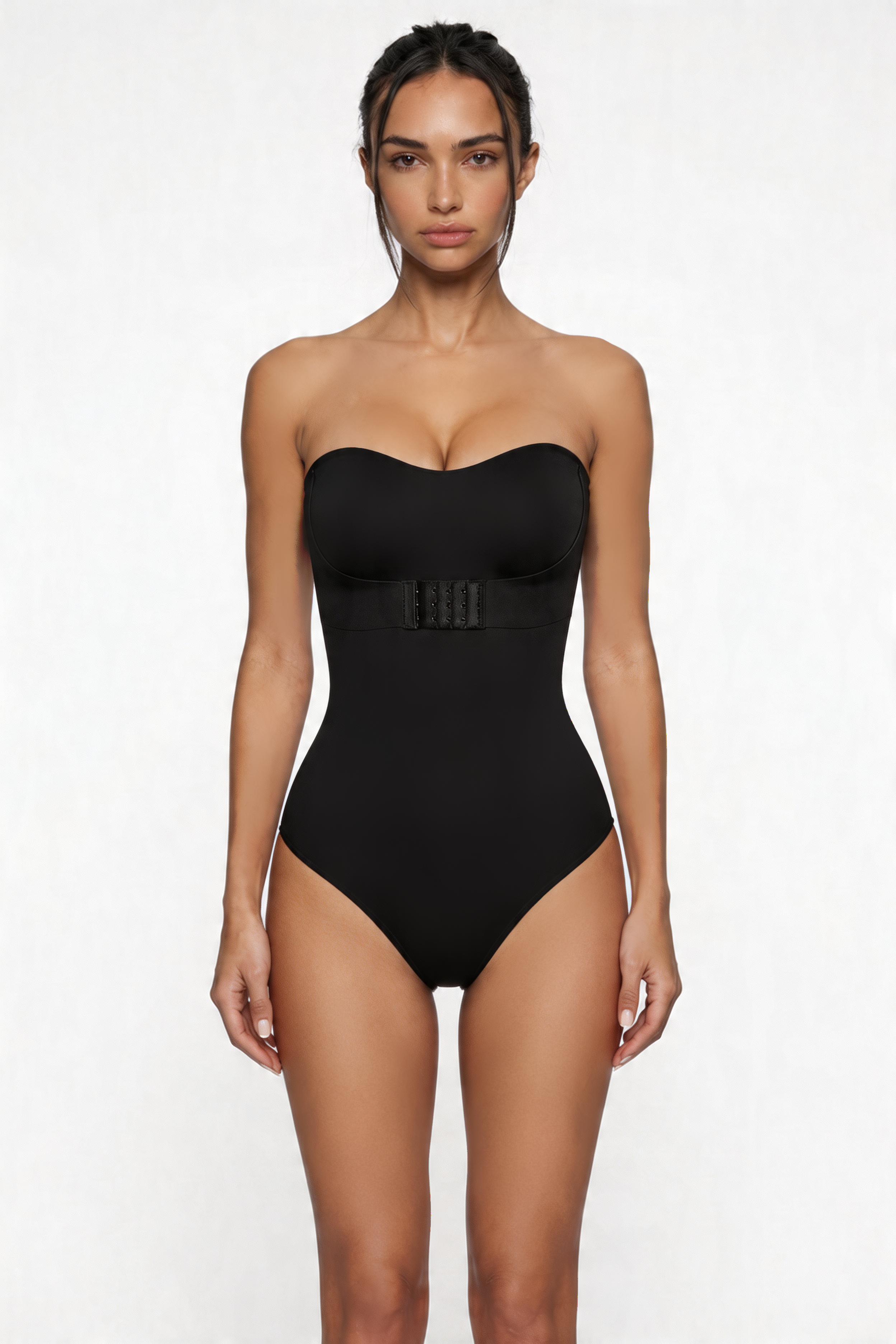 Woman wearing a black strapless shapewear bodysuit on a white background