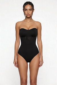 Woman wearing a black strapless shapewear bodysuit on a white background