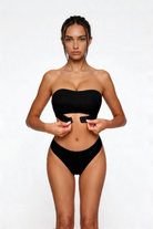Woman wearing a black shapewear on a white background