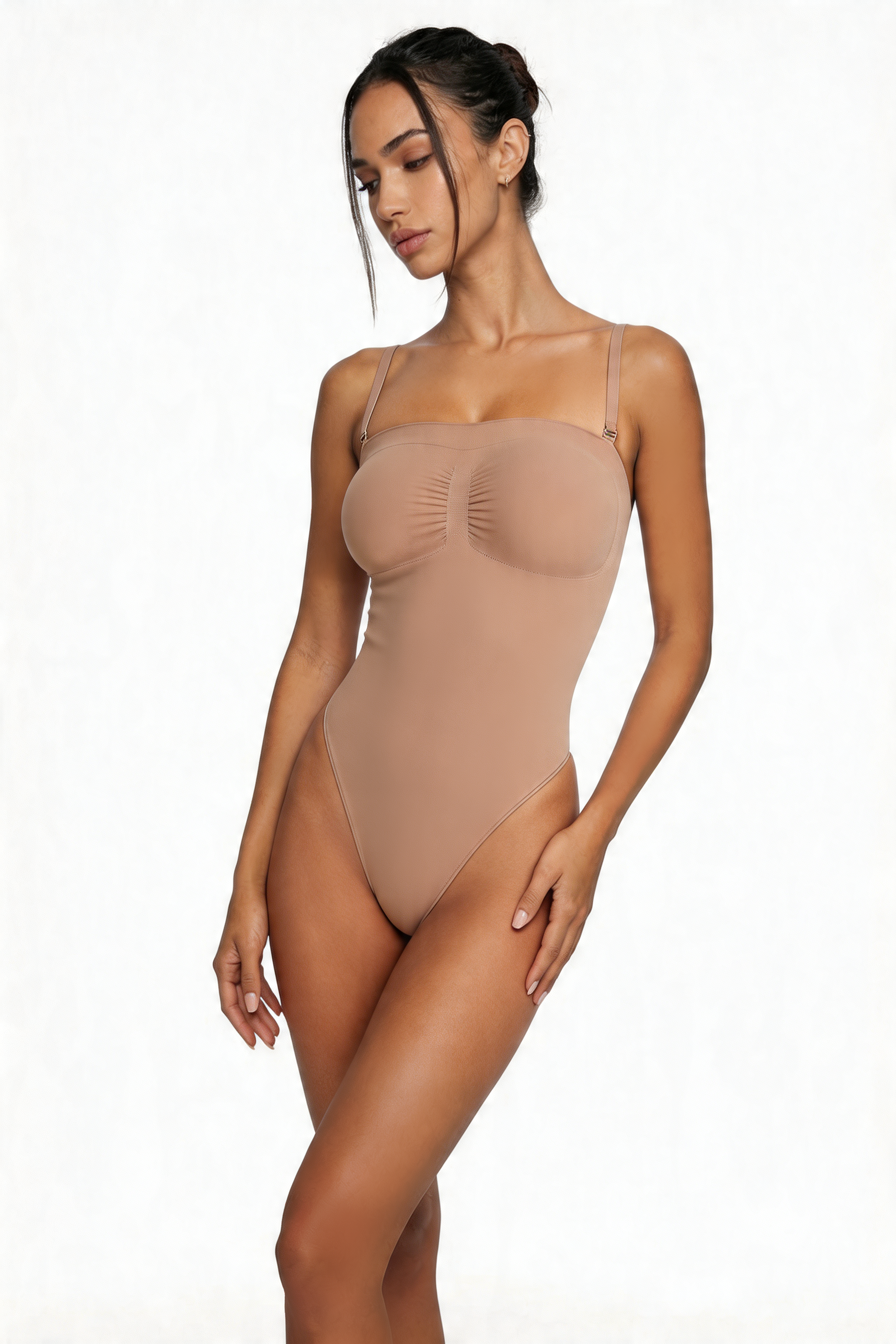 Woman wearing a beige shapewear bodysuit on a white background