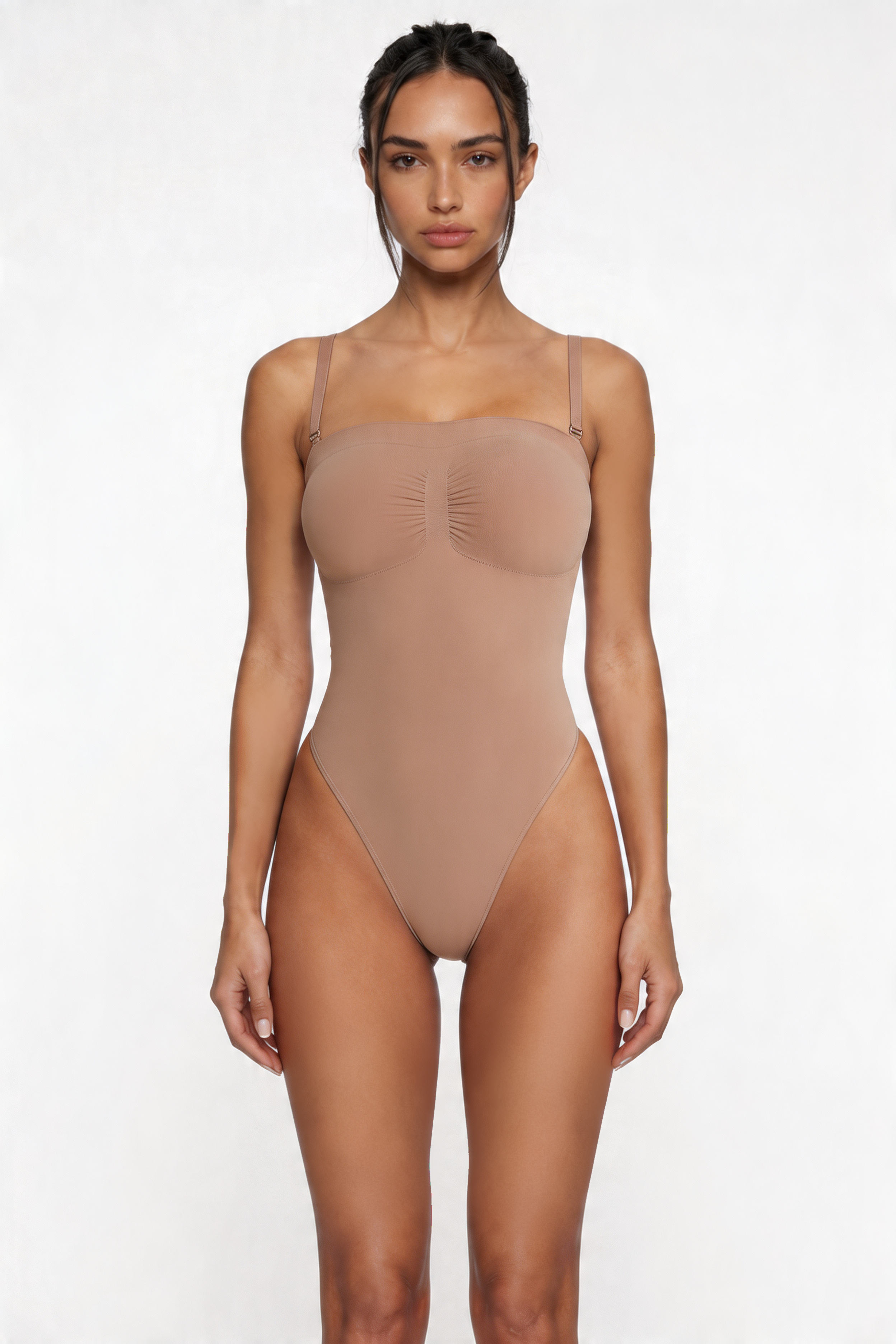 Woman wearing a beige shapewear bodysuit on a white background