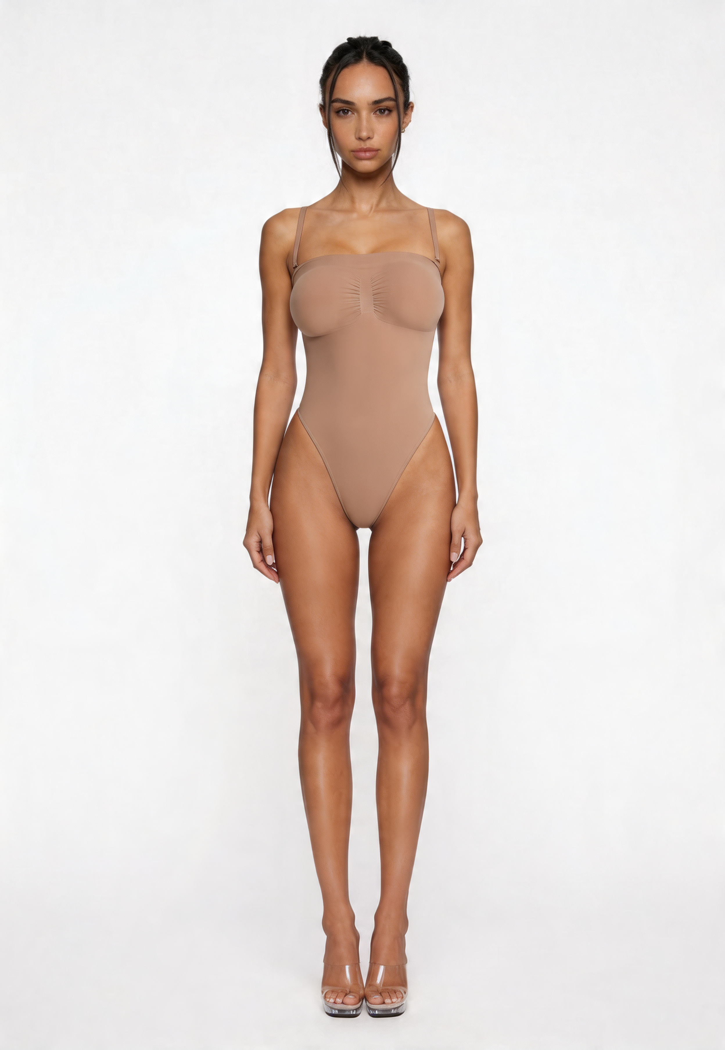 Woman wearing a beige shapewear bodysuit on a white background