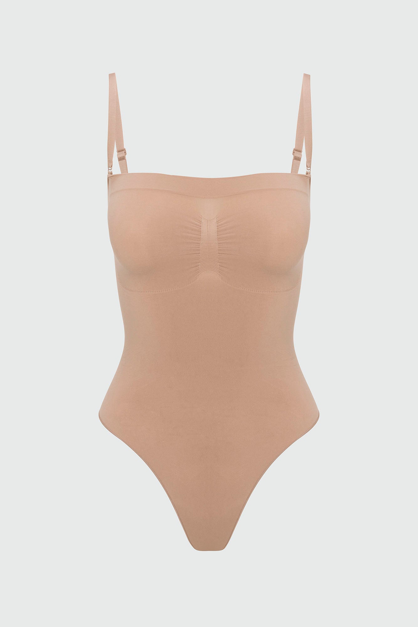 Beige shapewear bodysuit with thin straps on a light gray background