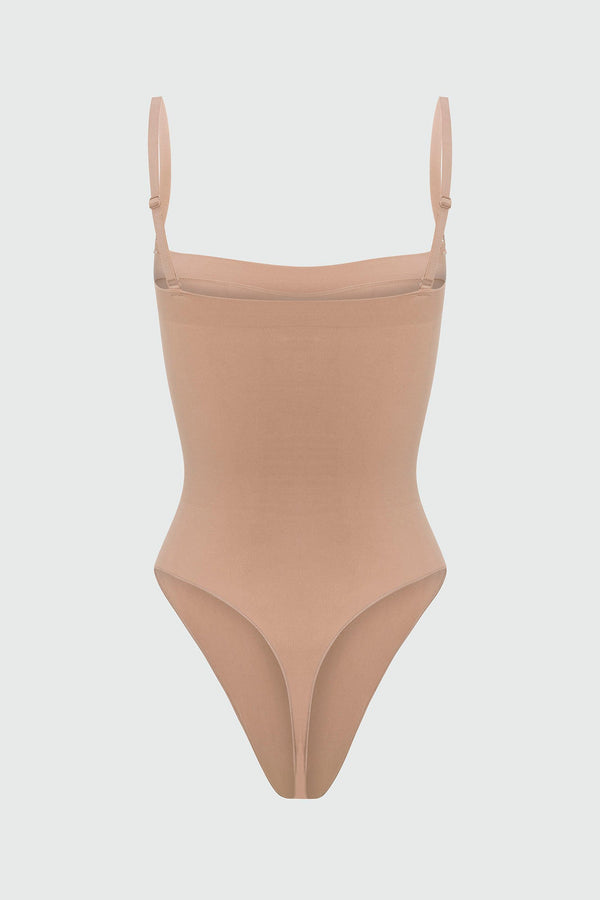 Beige shapewear bodysuit with thin straps on a light gray background