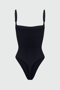 Black shapewear bodysuit with thin removable straps on a light gray background