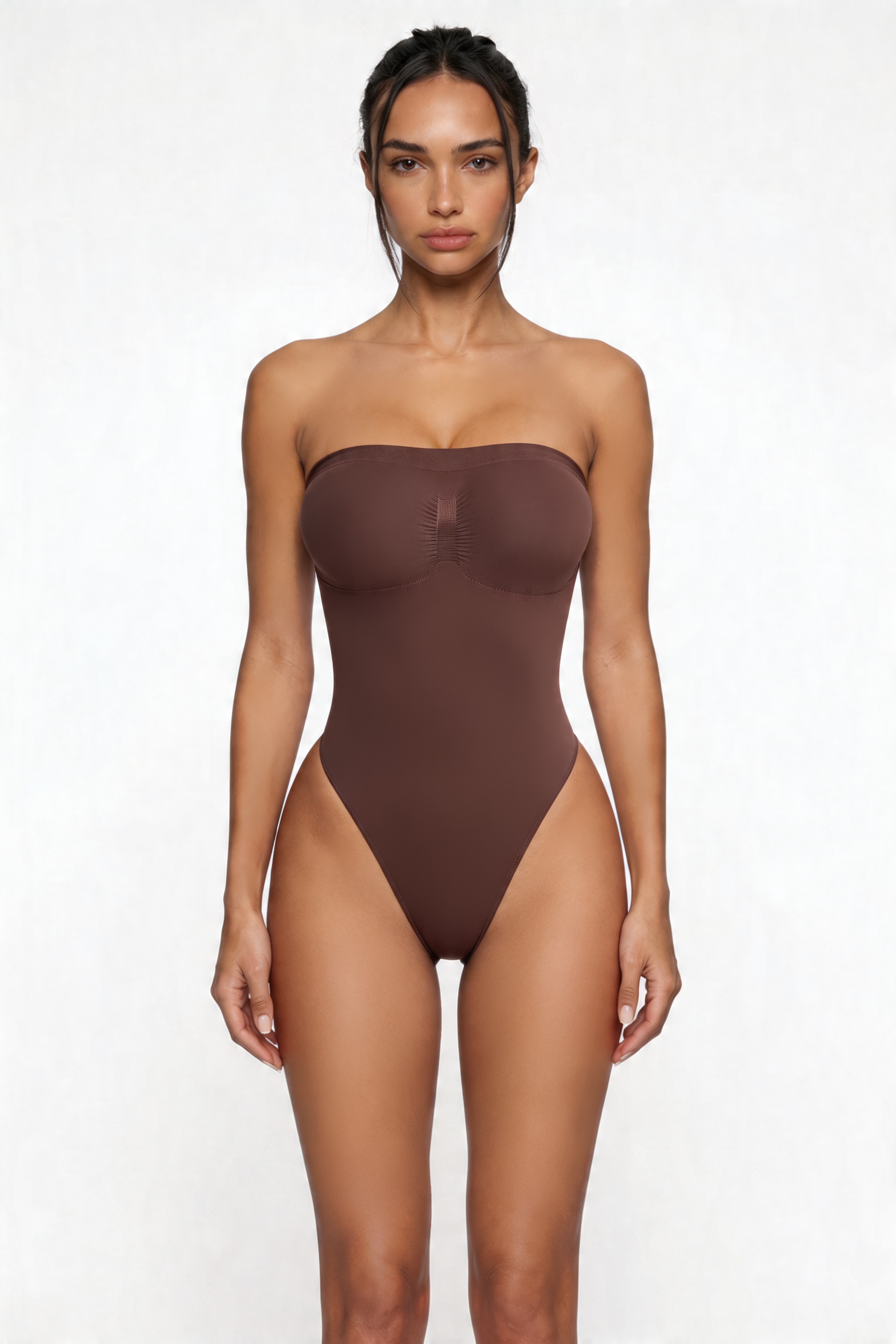 Woman wearing a brown strapless shapewear bodysuit on a white background