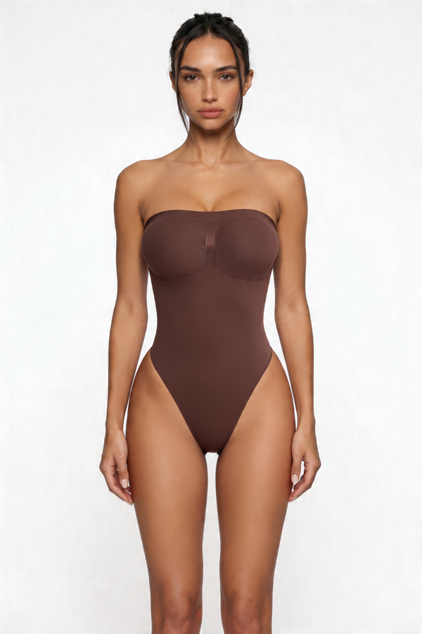 Woman wearing a brown strapless shapewear bodysuit on a white background